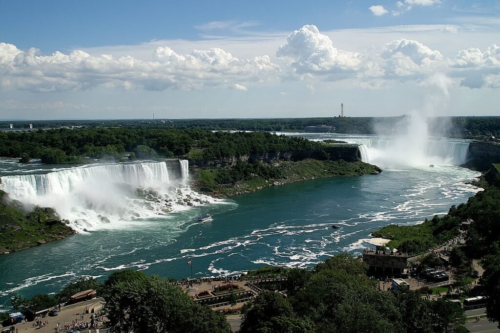Stunning view of Niagara Falls waterfall with mist rising and surrounding greenery