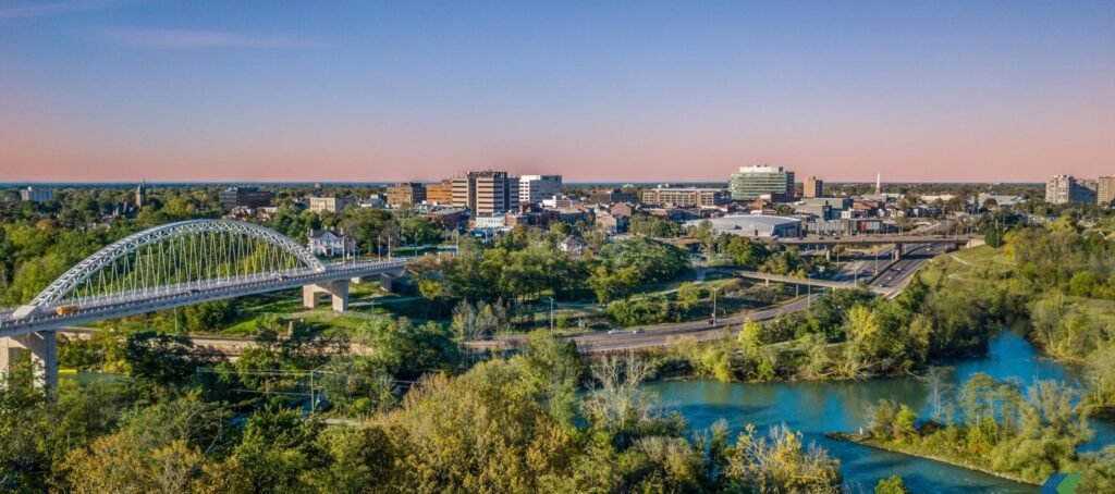 Aerial view of St. Catharines in the Niagara Region with a bridge over the Twelve Mile Creek and city skyline at sunset.